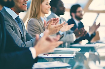 people at table applauding during meeting