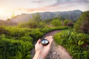 hand holding compass during hike